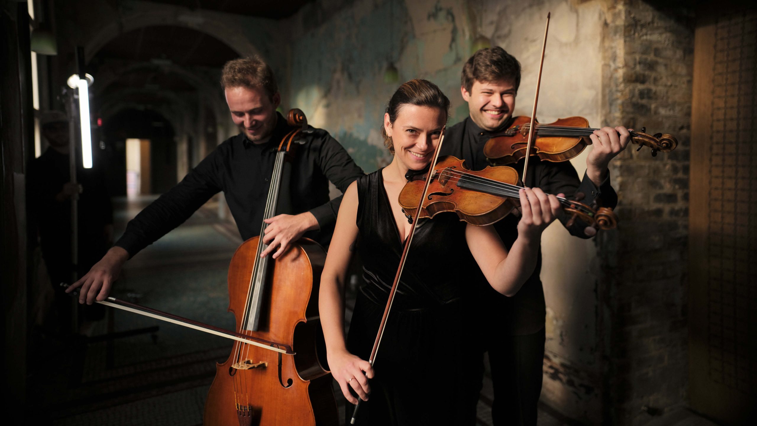 Chromatica Orchestra musicians playing violin and cello in a brand design campaign photoshoot. Brand identity by Alphabet Studio